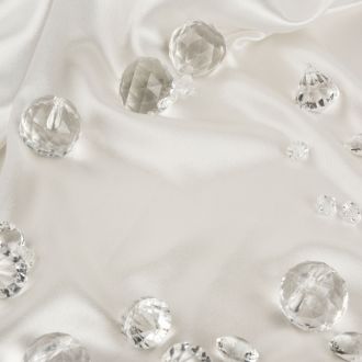 Decorative clear diamonds on white fabric textured background